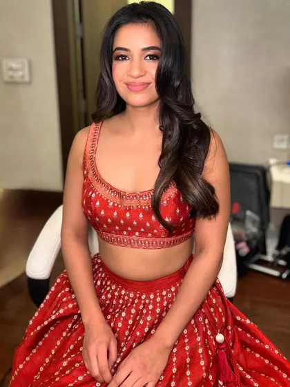 A bright, happy smile from the client, showing her final look in natural light. Our goal is to make you feel comfortable and beautiful, ready for any celebration.