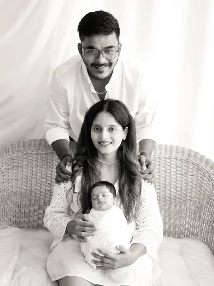 Another classic family pose in black and white, with the parents standing behind their baby.