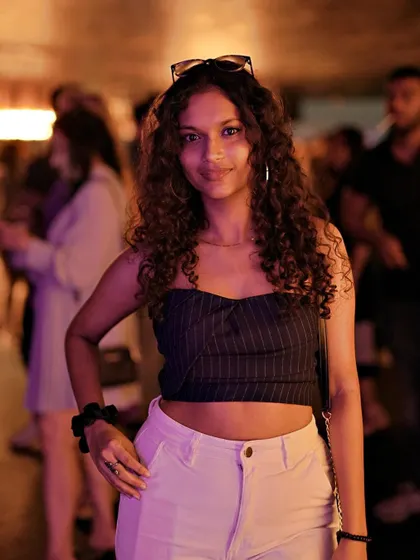 A guest with beautiful curly hair, posing for a photo at Kaze.