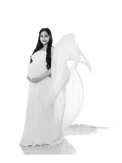 A high-key black and white portrait of a mom-to-be in a flowing gown. The bright, airy feel is both modern and timeless.