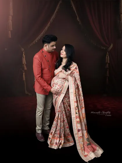 A traditional portrait celebrating heritage and love. The couple looks elegant in their ethnic wear, sharing a quiet moment of anticipation.