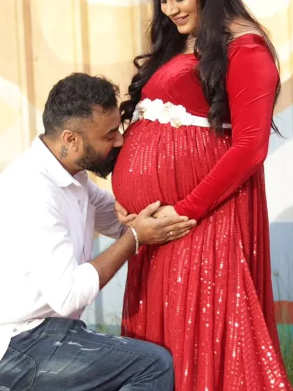A beautiful, intimate moment from a maternity photoshoot. The client is wearing my red sequin and velvet gown, which adds a touch of glamour and warmth to pregnancy portraits.