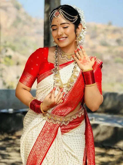 A smiling model wearing a complete Kerala-style jewellery set, including the waist belt and bangles, perfect for a traditional photoshoot.