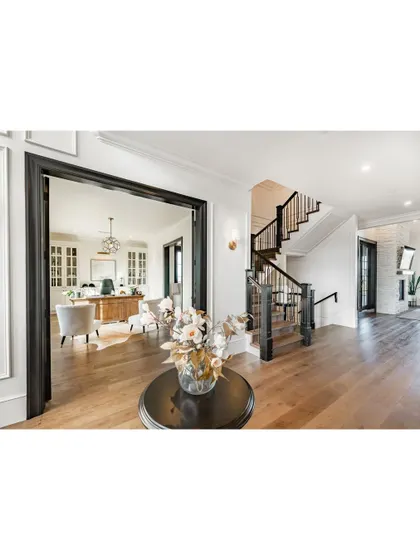 A view from a hallway into a home office, showcasing how we use bold trim and doorways to frame a space. The dark-stained wood creates a beautiful contrast with the light walls and flooring.