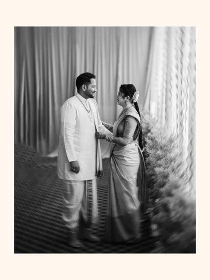 A beautiful black and white portrait of the couple, the bride adjusting the groom's attire.