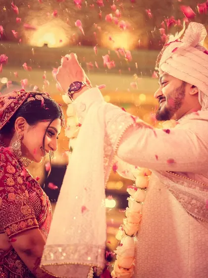 The joy of a varmala ceremony is infectious. We capture the energy with dynamic shots, like this one where the couple is showered in petals, freezing a perfect, happy memory in time.