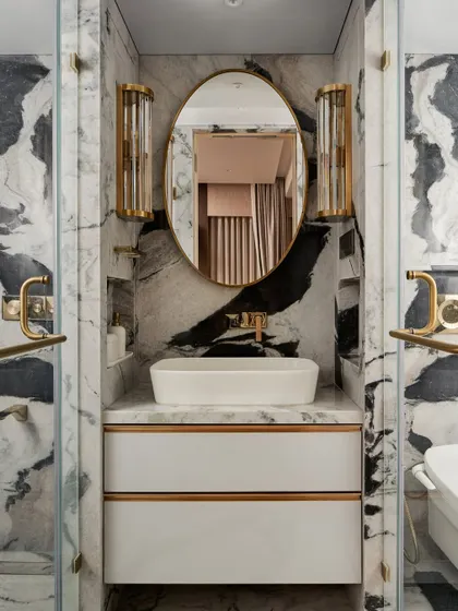 The master bathroom is a study in luxury, with dramatic black and white panda marble and brushed gold fittings. We designed the space to feel like a private sanctuary, with every detail carefully considered.