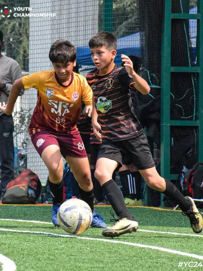 Two players locked in a battle for possession during a Youth Championship match.