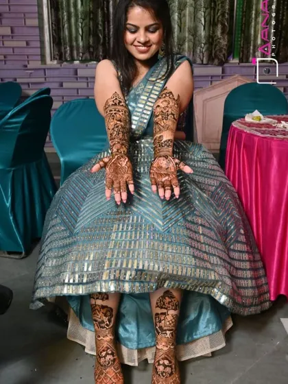 A happy bride showing her complete bridal mehandi. The designs on her hands and feet are perfectly coordinated.