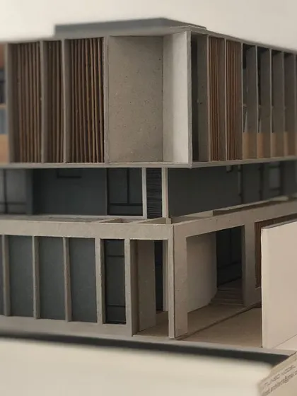 A physical model of a residential facade, showing the interplay between solid concrete forms and delicate wooden screens. This study model helps us refine the proportions and material composition of the design.