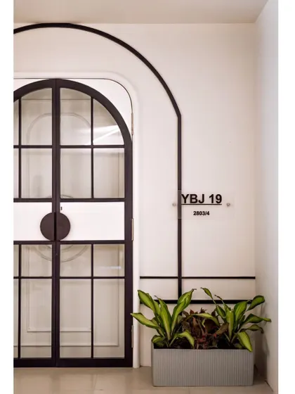 Another view of the entrance, with the custom nameplate and a simple planter. Every detail is carefully curated to create a welcoming and sophisticated first impression.