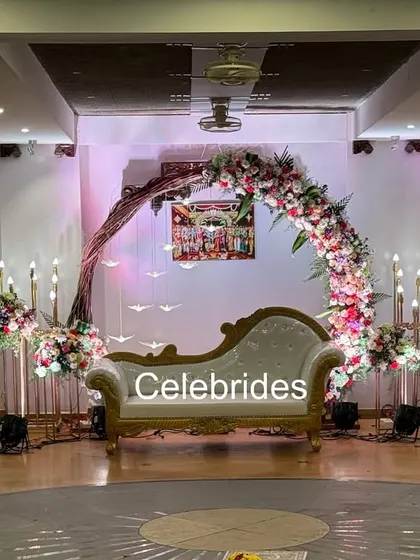 A modern engagement stage with a crescent floral arch and hanging bird props. The combination of flowers and unique elements creates a stylish look.