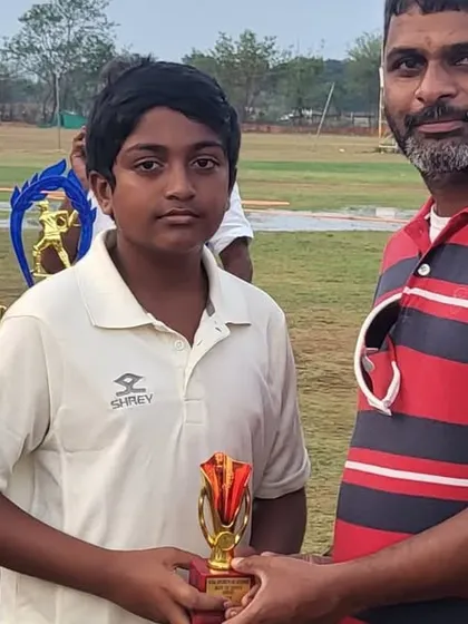 A young player receives his award in front of a table full of trophies during our successful Hyderabad tour.