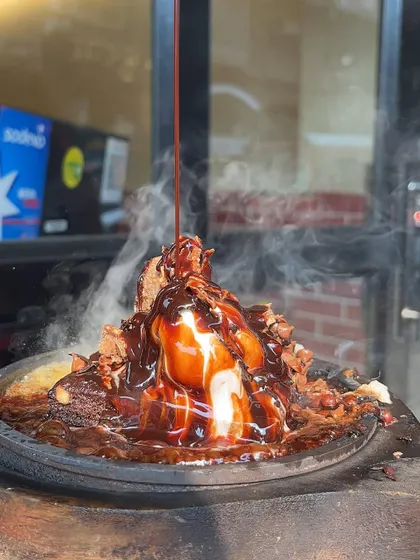 The moment the rich chocolate sauce is poured over the Sizzling Brownie and ice cream, creating a spectacular dessert experience.
