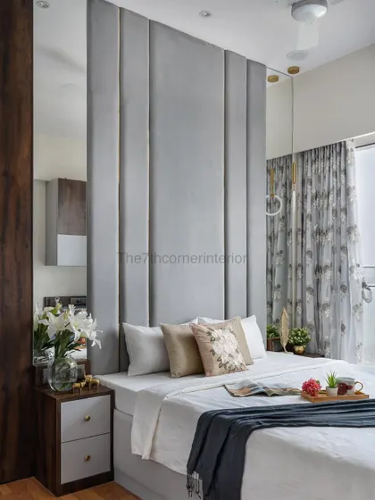 This master bedroom promotes calm vibes with its muted neutral tones. The tall grey headboard with gold inlay adds a touch of luxury, creating a space that feels both restful and uplifting.