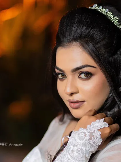 A close-up of a model's face, showcasing a beautiful Christian wedding makeup look with defined eyes and a soft lip.