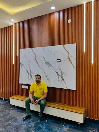 Taking a moment to appreciate the finished full-wall TV unit. The contrast between the dark wood and the white marble panel is striking.