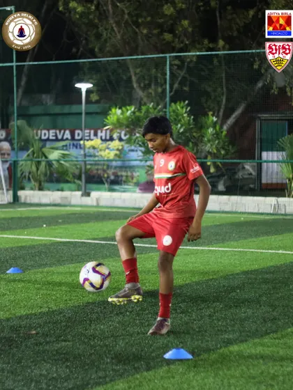 A young player navigates a cone drill, working on his close control and agility. These drills are the building blocks for becoming a skilled and elusive player.