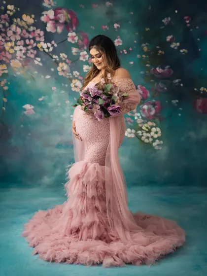 Adding a bouquet of flowers can bring a lovely, soft touch to a glam session. This mama looks absolutely serene in her pink gown, holding a beautiful purple arrangement.
