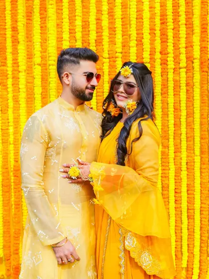 A sweet, candid moment between the couple during their Haldi shoot. Their smiles and relaxed posture reflect the happy and informal nature of the celebration.