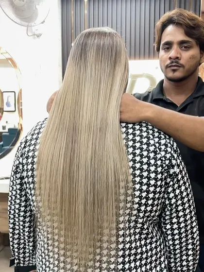 Our stylist proudly presenting the final result of this stunningly long, sleek, ash-blonde color and style.