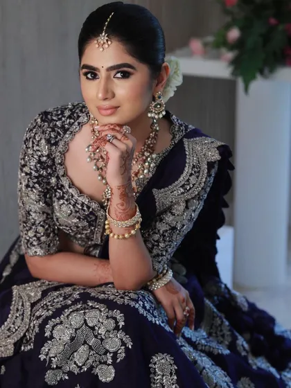 A close-up that highlights the dramatic eye makeup and the intricate jewelry.