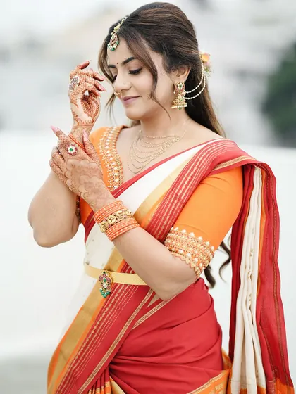 A graceful pose highlighting the delicate henna work. Even from a distance, the mehendi adds a layer of artistry and tradition to her overall appearance.