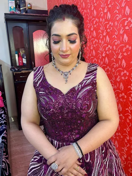 A close-up of the client's makeup, showing the soft glam look that complements the purple gown.