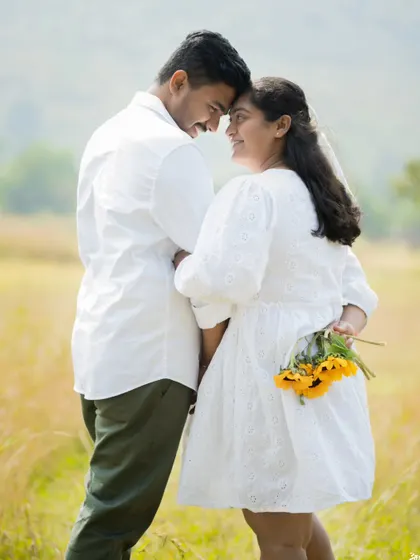 A playful and romantic pre-wedding portrait, with the groom holding sunflowers behind his back.