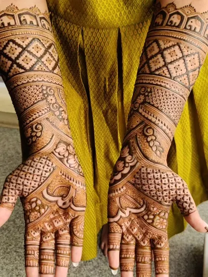 A full-coverage design with a mix of paisley and geometric patterns. The top of the arm is finished with a border of small elephants, a popular bridal motif.