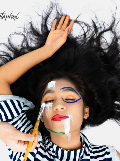 An artistic and creative portrait that uses face paint as a central theme. This overhead shot captures a unique concept, blending art and photography for a visually compelling editorial-style image.