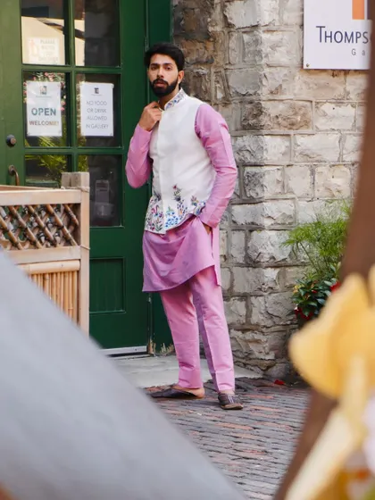 This outfit is all about fresh, festive style. The pink kurta provides a pop of color, while the white Nehru jacket with its beautiful floral embroidery adds a layer of elegance.