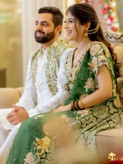 A candid side-profile shot of the couple enjoying their Mehndi event.