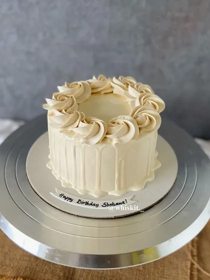 A simple and elegant cake with a coffee-flavored drip and a border of piped rosettes. A classic design that's always in style.