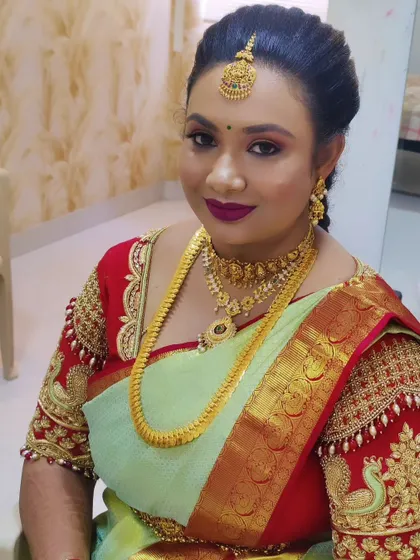 A glamorous look for a party or function. This client is wearing a light green saree with a heavily embroidered blouse, paired with a bold lip and smokey eyes.