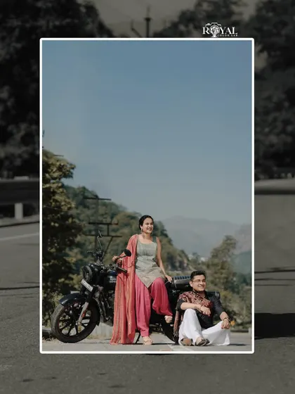 A stylish shot of a couple in ethnic wear posing with a motorcycle, blending tradition with a modern, adventurous spirit.