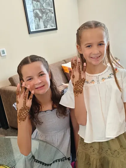All smiles from these two sisters, proudly showing off their new henna.