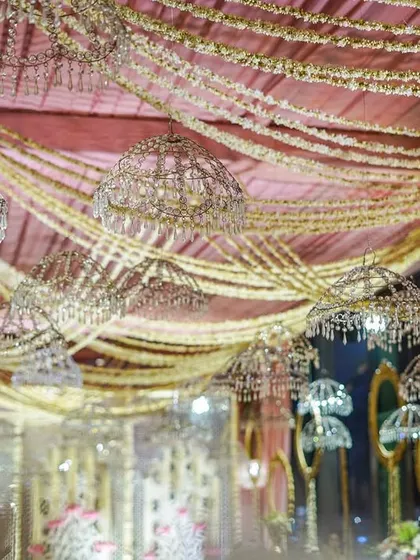 Another angle of the ceiling, showing the beautiful crystal umbrellas and draped pearl garlands. The lighting creates a warm and inviting glow throughout the space.