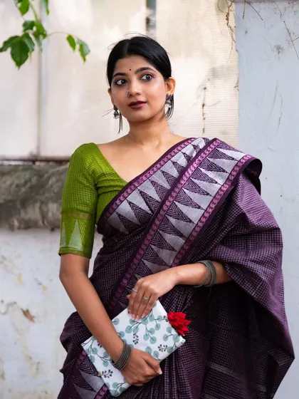 Holding a book and a single red rose, this pose in a purple Sungudi saree evokes a sense of classic romance and intellect. The green blouse provides a beautiful contrast.