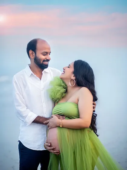 A close-up filled with love and laughter. The genuine smiles in this beach maternity photo are what make it so special and heartwarming.