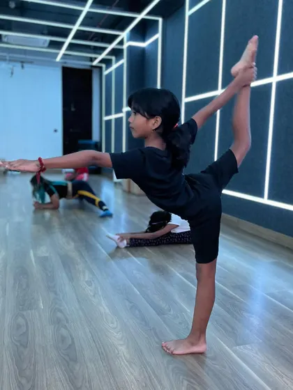 This student holds a graceful standing split, a pose that requires both balance and flexibility, which are core components of my training.