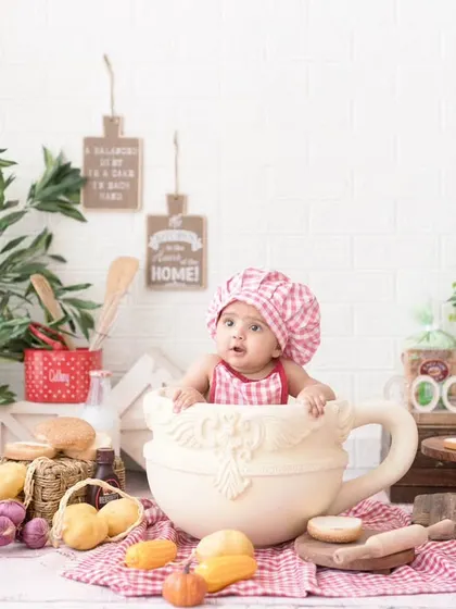 The cutest little chef in her kitchen. Our baking-themed setup is filled with fun props like a giant teacup, mini breads, and a chef's hat for a deliciously sweet photoshoot.