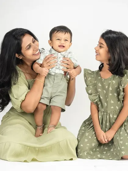 A lovely studio portrait of a mother with her two children. The coordinated outfits and gentle interaction highlight the sweet bond between siblings and their mom.