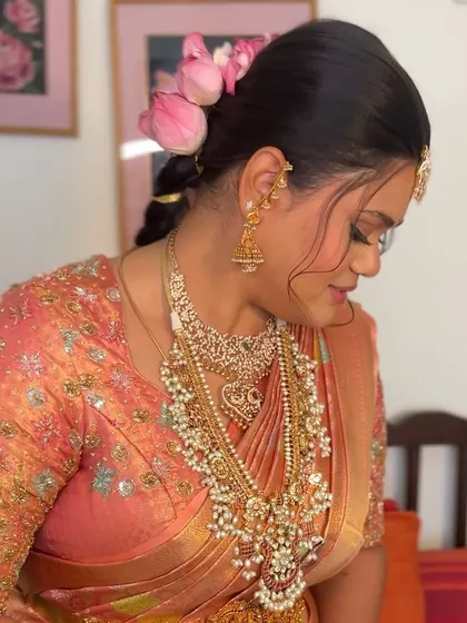 A side view of the beautiful hairstyle using lotus petals. It adds a soft, ethereal touch to the overall bridal look.