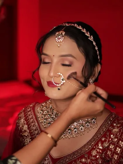 Applying blush to bring a natural flush to the bride's cheeks, completing her radiant look.