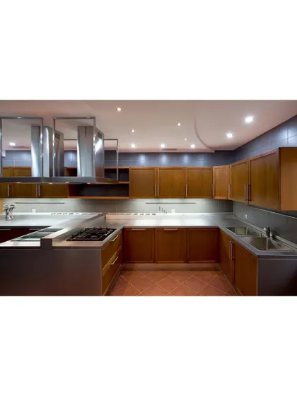 A commercial-style kitchen with stainless steel countertops and wooden cabinets. The robust design is perfect for those who are serious about cooking and need a durable and functional workspace.