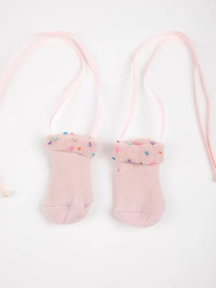 A product shot of the adorable pink baby socks with tie-strings.