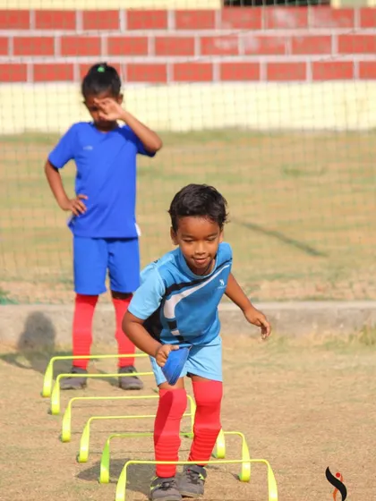 This young athlete focuses on clearing the hurdles, building explosive power and agility during a training session.