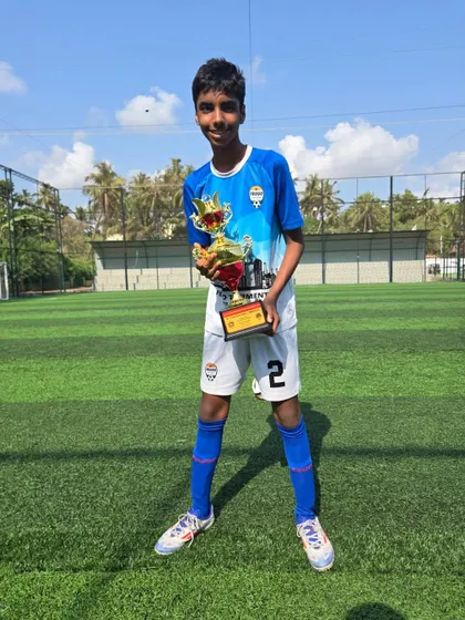 A member of the U14 Feugo Lions team with his championship trophy.