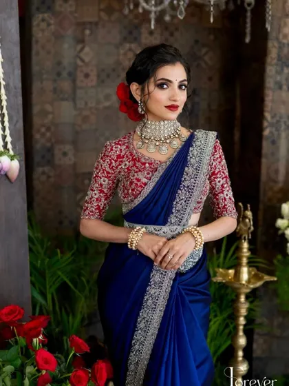 A pop of red from a flower in her hair adds a beautiful touch to this reception look, tying in with her bold red lip and embroidered blouse.